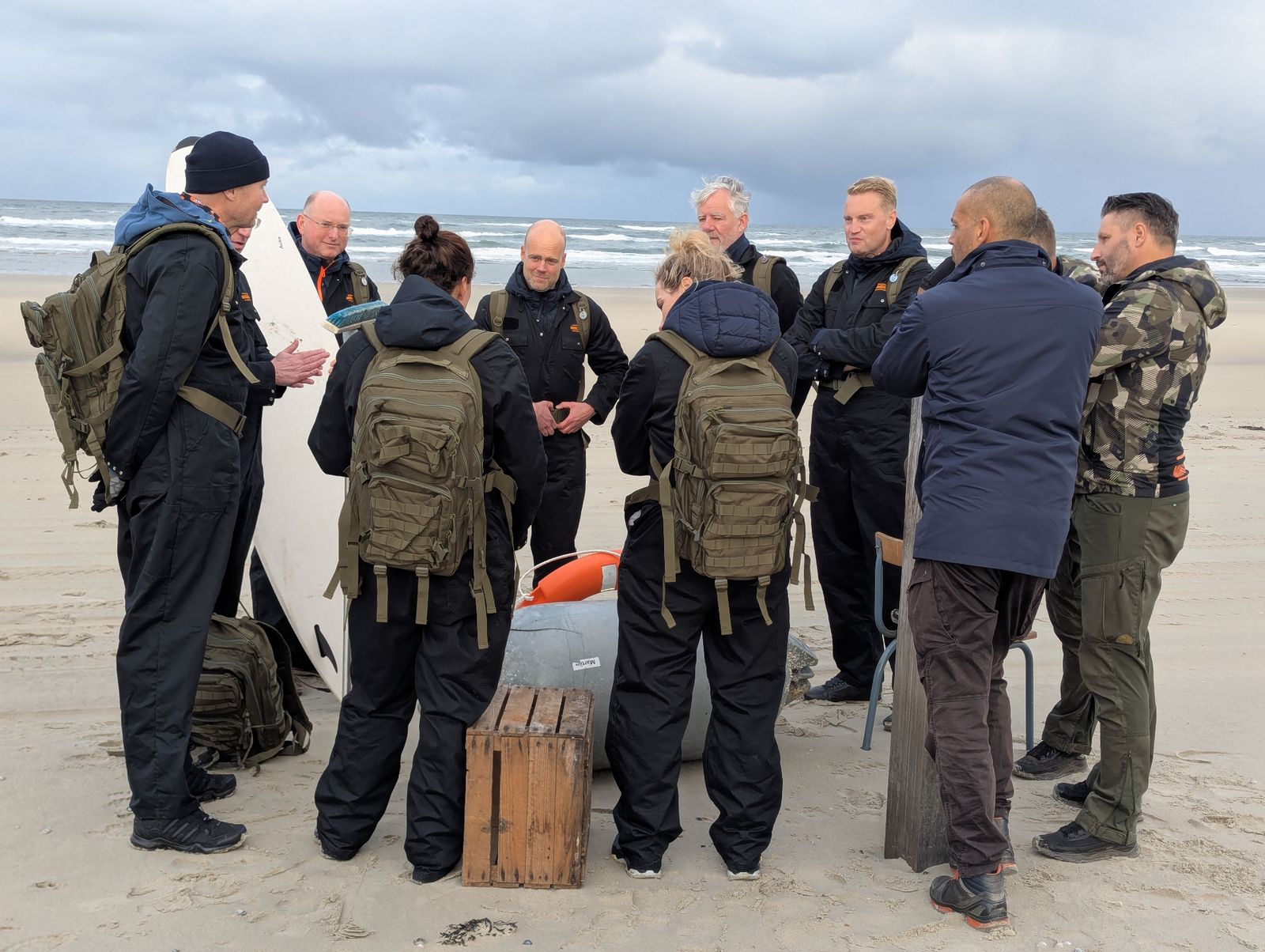 Groep in overall op het strand tijdens een eilandactiviteit
